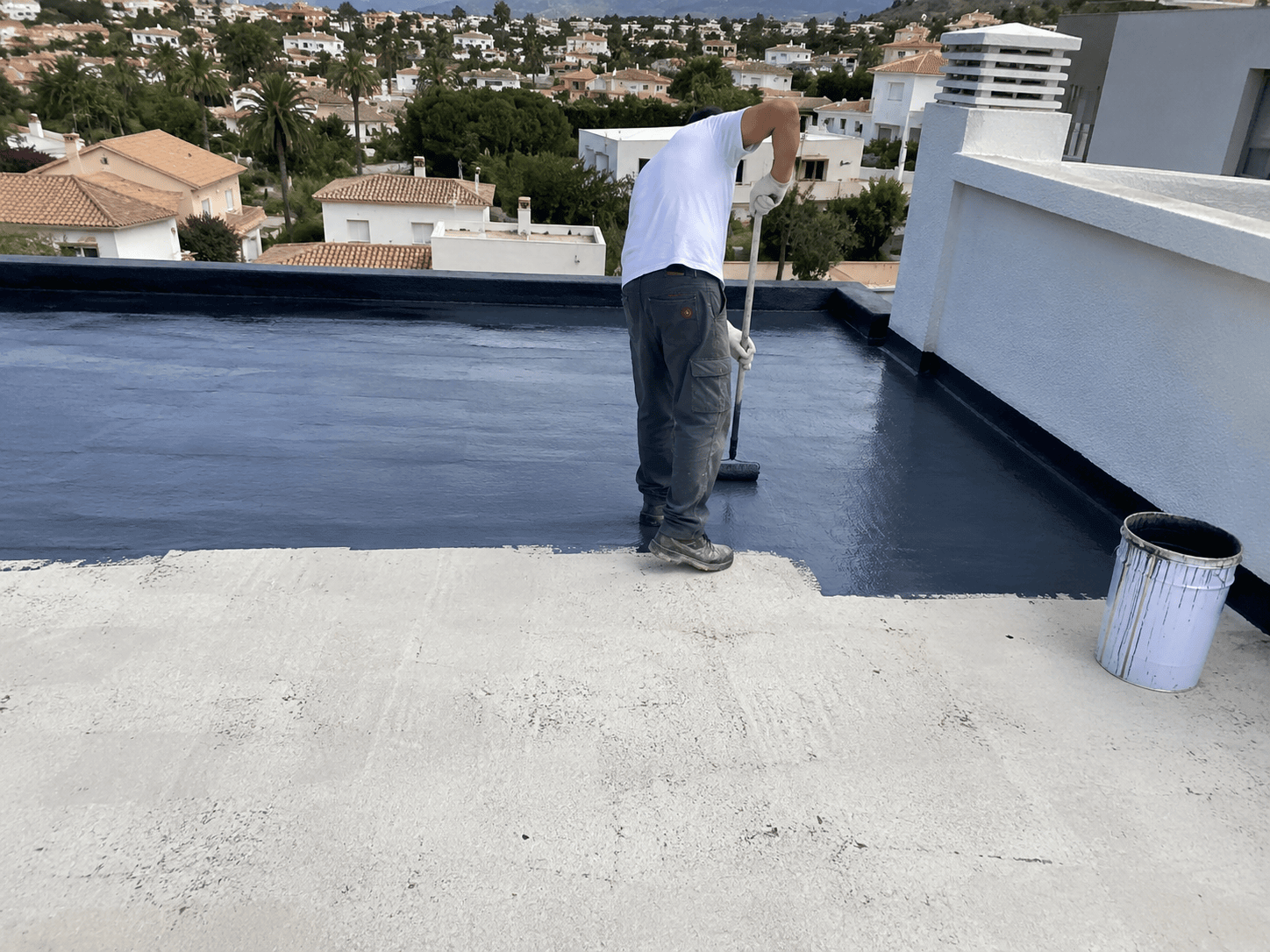 Operario aplicando un revestimiento impermeabilizante en una cubierta plana de Jávea