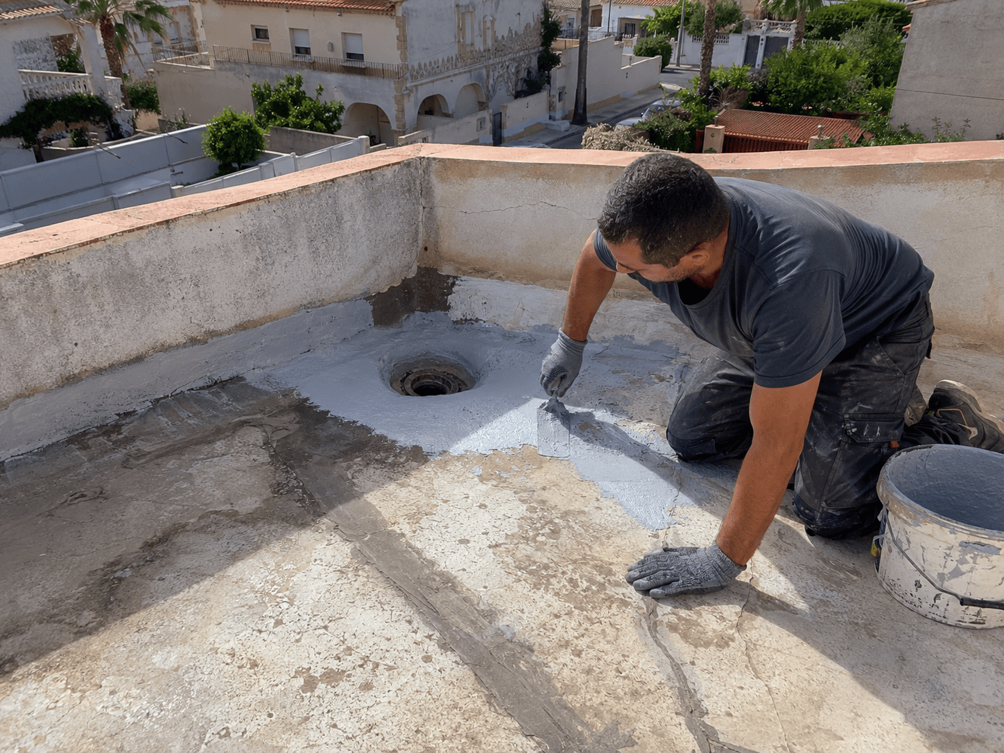 Operario reparando goteras junto al desagüe de una terraza en Santa Pola